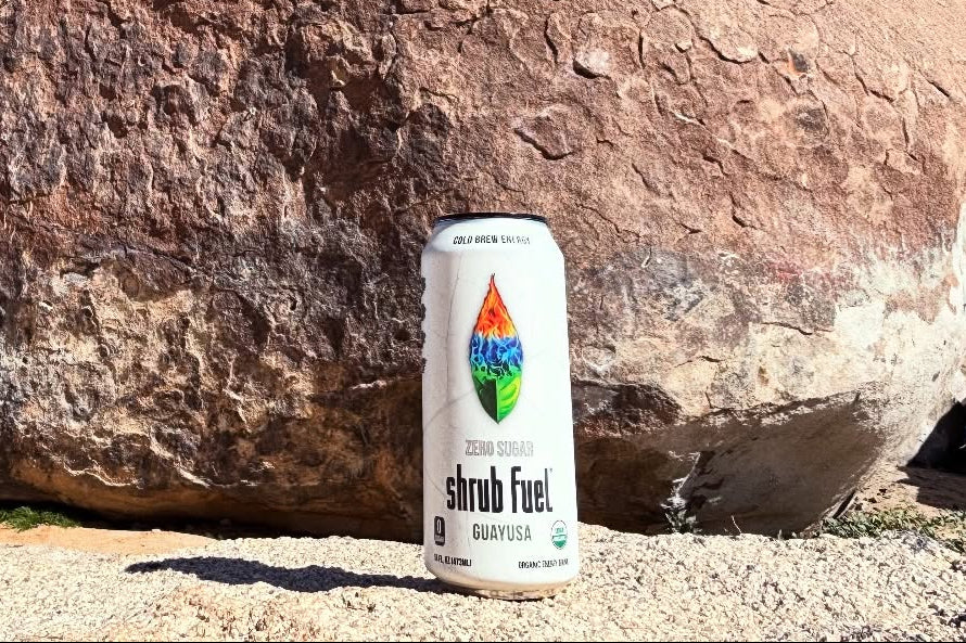 Large rock in a desert landscape with a can of shrub fuel in front